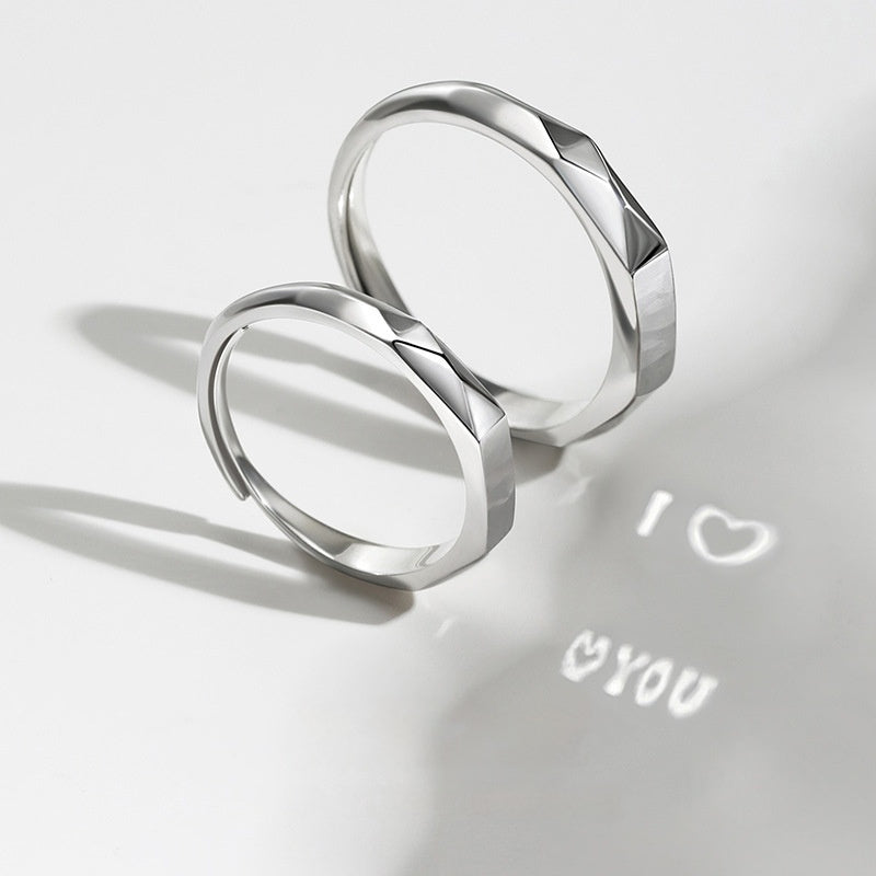A pair of Jingqian S925 Sterling Silver Light Reflection Rings featuring a geometric design, positioned on a white surface. Light shining through the adjustable rings casts a shadow that reads "I ♥ YOU" on the surface, with the heart shape symbolizing the word "love.