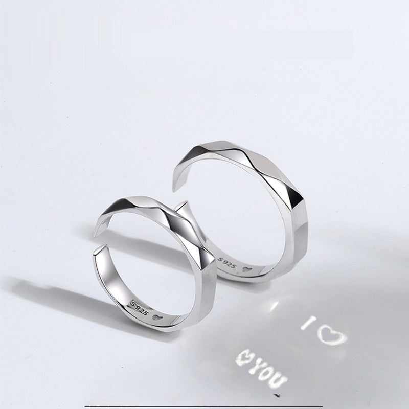 A close-up image of two Jingqian S925 Sterling Silver Light Reflection Rings with faceted surfaces, arranged in a mirrored fashion. A shadow below them displays the text "I ♡ YOU" with a heart symbol between "I" and "YOU", creating a romantic impression enhanced by the light reflection from the rings.