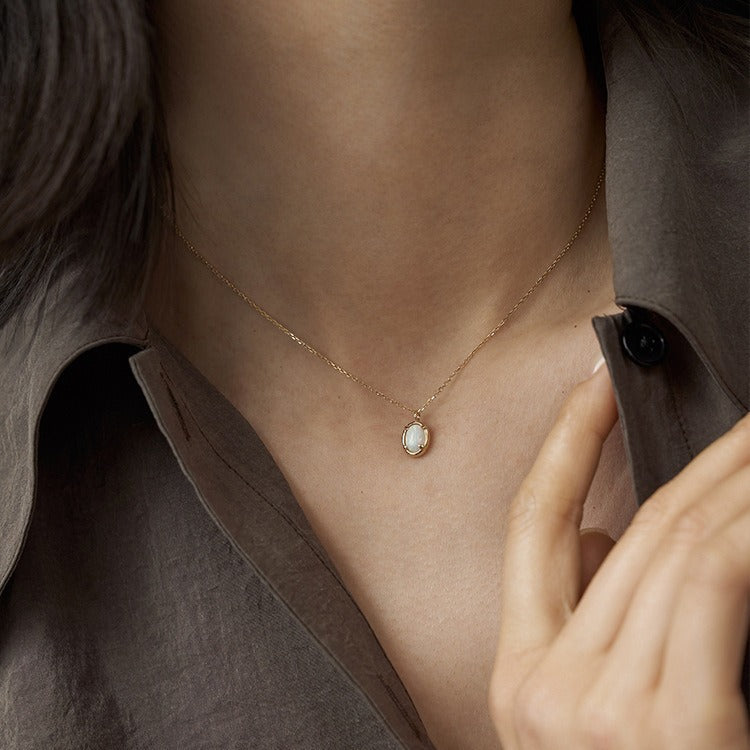 Necklace with a pendant worn by a person, focusing on the jewelry.