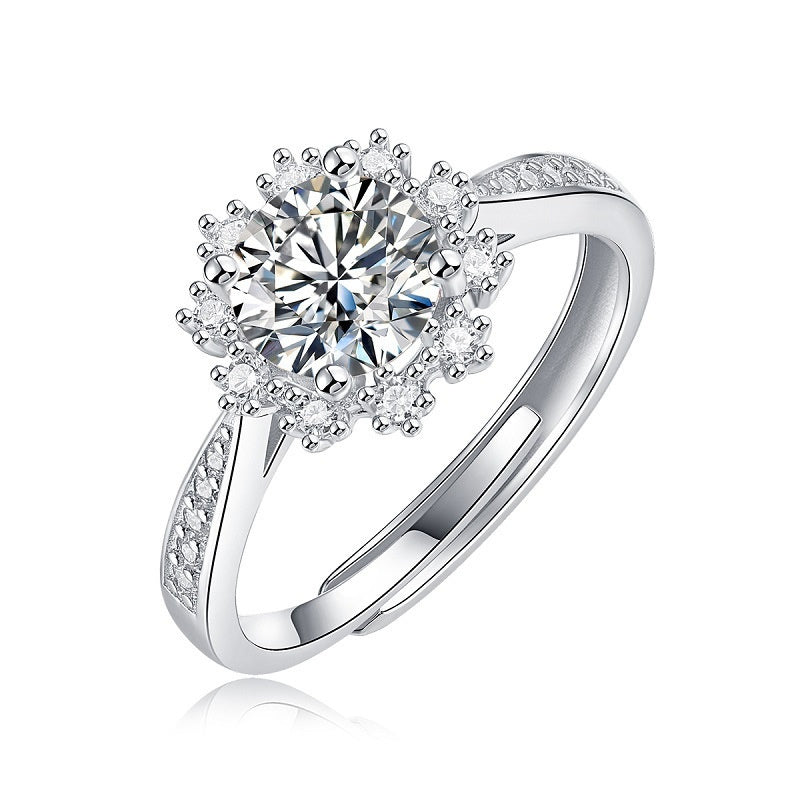 Silver ring with a large central diamond and smaller diamonds on the band against a white background