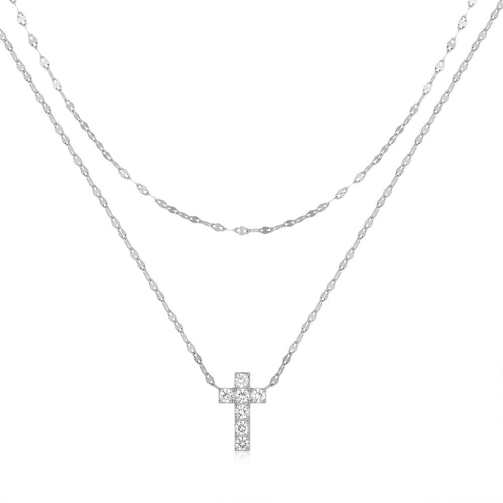Silver cross necklace on a white background